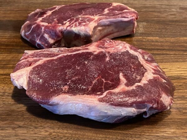 Two aged grass-fed bone-in ribeye steaks